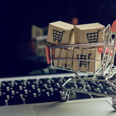 Shopping online concept - Parcel or Paper cartons with a shopping cart logo in a trolley on a laptop keyboard. Shopping service on The online web. offers home delivery..