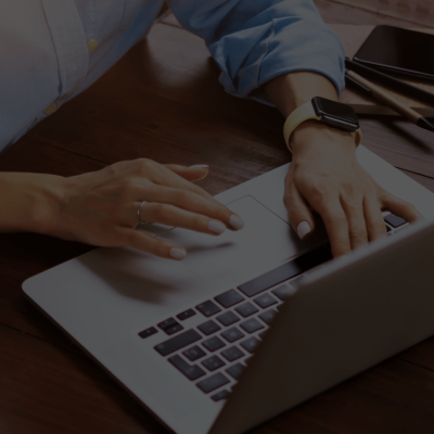 Hands held over a chrome laptop